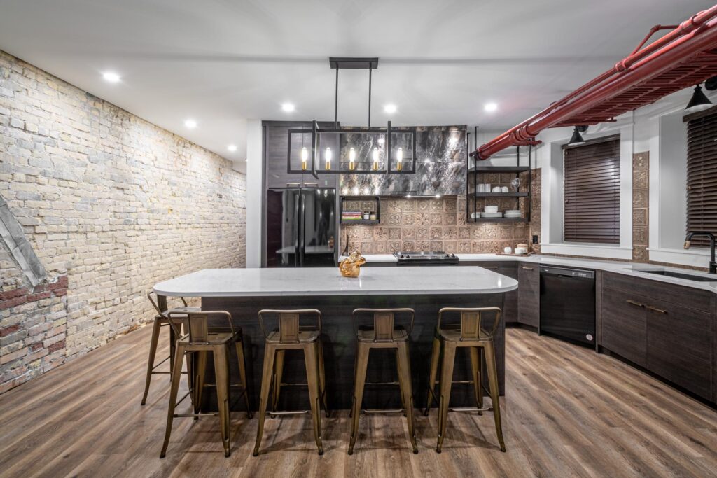 Recessed and pendant lighting in an exposed-brick kitchen wired by North Star Electric in Winnipeg, Manitoba